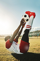 Image showing Soccer, sports and stretching with a black man athlete training with a ball before a game or match outdoor. Football, fitness and workout with a male getting ready for sport on a grass pitch or field