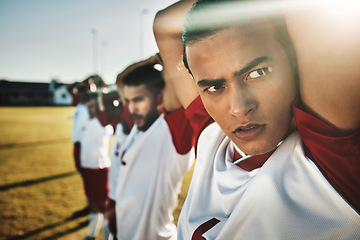 Image showing Face, soccer and stretching with a sports man getting ready for a game or workout with his team on a grass pitch or field. Football, fitness and training with a male athlete warming up for exercise