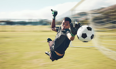 Image showing Soccer, sports and goalkeeper with a man saving a shot, goal or score during a game on a grass pitch field. Fitness, football and training with a male athlete making a save during a practice session