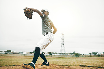 Image showing Baseball, pitcher and sports, athlete man and throw a pitch during a competitive game or match on a court. Fitness, workout and exercise with a pro male player training or practice outdoor on field