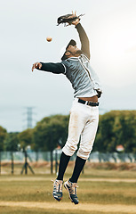 Image showing Baseball, sport and person fielder jump on an outdoor sports field during sport game or match. Fitness, training motivation and cardio workout of an athlete man with focus ready to catch a fast ball