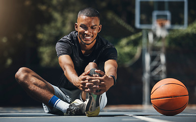 Image showing Training, basketball player and man stretching legs in outdoor community court, muscle energy and healthy sports game performance. Happy, strong and young male athlete warm up exercise in competition