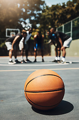 Image showing Basketball, ball and outdoor court with athlete group or team talk strategy during break at game for motivation and teamwork for streetball. Male players in the USA playing for fitness and exercise