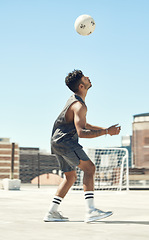 Image showing Training, soccer and man with ball in air trick on city rooftop in Brazil for outdoor playing. Football, workout and athlete male practicing technique with focus, concentration and dedication.