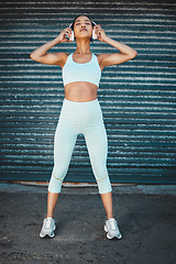 Image showing Healthy, fitness and workout woman listening to music on wireless headphones outdoor after cardio training. Music, audio and exercise with a sporty young athlete with motivation, wellness and focus