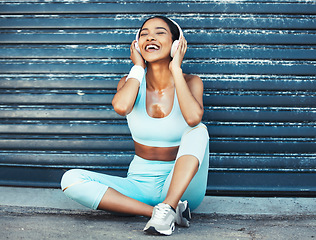 Image showing Fitness, music and happy woman with headphones sitting on ground for outdoor workout or running break. Sports, exercise and listening to streaming app on earphones enjoying favorite training playlist