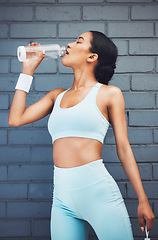 Image showing Fitness, woman and drinking water for sports hydration after workout, exercise and training against wall background. Active female in healthy rehydration for physical activity, wellness and diet plan