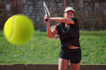 Image showing A professional female tennis player serves the tennis ball on the court with precision and power