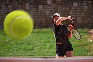 Image showing A professional female tennis player serves the tennis ball on the court with precision and power