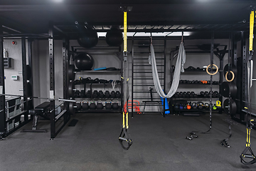 Image showing An empty modern gymnasium with a variety of equipment, offering a spacious, functional, and well-equipped training facility for workouts, fitness, and strength training