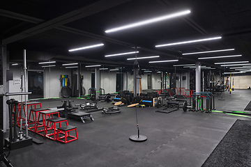 Image showing An empty modern gymnasium with a variety of equipment, offering a spacious, functional, and well-equipped training facility for workouts, fitness, and strength training