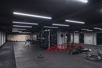 Image showing An empty modern gymnasium with a variety of equipment, offering a spacious, functional, and well-equipped training facility for workouts, fitness, and strength training