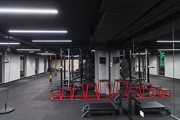 Image showing An empty modern gymnasium with a variety of equipment, offering a spacious, functional, and well-equipped training facility for workouts, fitness, and strength training