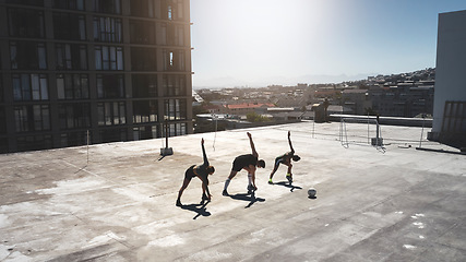 Image showing Fitness group, stretching and ball sports with friends doing exercise, workout and warm up on city building rooftop on a summer day. Athlete man and women during soccer training or football practice