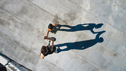 Image showing High five, support and success in rooftop fitness, workout or training in Canada for health, wellness or cardio exercise. Top view, teamwork or collaboration gesture for sports friends, man and woman