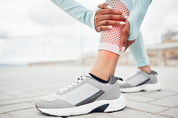 Image showing Fitness, shoes and injury with a sports woman holding her leg in pain during exercise or a workout outdoor in the city. Training, anatomy or accident with a female athlete suffering from inflammation