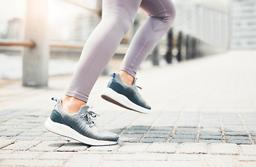 Image showing Running shoes, feet sneakers and city cardio exercise, marathon and sports training in urban outdoor. Closeup woman athlete foot, legs and fast running speed of healthy fitness runner sprint movement