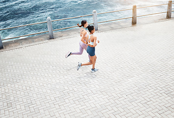 Image showing Beach, women and fitness friends running on sidewalk at the ocean for exercise, cardio workout and training outdoors. Healthy, wellness and sports runners exercising together at sea or waterfront