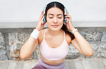 Image showing Fitness, music and woman with headphones sitting on ground to relax after outdoor workout, running or yoga. Sports, exercise and streaming motivation or meditation app and enjoying calm playlist.