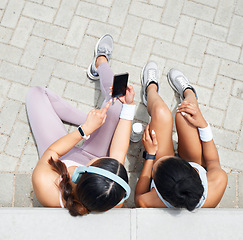 Image showing Women in city, online workout app in Miami and healthy friends relax sitting on urban floor watching fitness video. Girl streaming audio podcast, show social media exercise and outdoor 5g technology