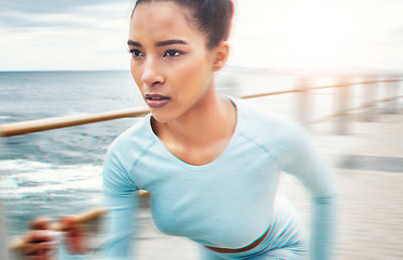 Image showing Fast, fitness and woman running in nature for cardio health, wellness and sports motivation by the ocean. Face of an athlete runner with speed, training and doing a workout for exercise by the sea