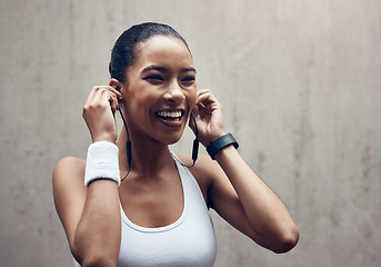 Image showing Music, fitness and exercise with a sports woman streaming audio during training or a workout on a gray background. Health, cardio and training with a female runner listening on earphones during a run