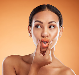 Image showing Beauty, makeup and cosmetics with woman using hands to pout lips with makeup for cosmetology advertising against orange background. Face of female model showing tint, mouth and colour for skincare