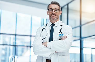 Image showing Doctor, senior man and arms crossed with glasses and stethoscope in medical healthcare clinic. Health medic research expert, science innovation leader and proud professional surgeon in hospital