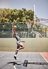 Image showing Basketball, sports and jump with man on court playing games for fitness, training and health. Energy, exercise and workout with basketball player in outdoor for wellness, summer and athlete lifestyle