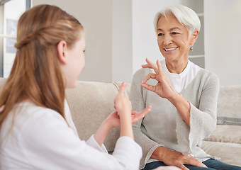 Image showing Senior woman, sign language and deaf girl communication, talking or conversation in home. Support, care and retired old female speaking to child with hearing disability in asl language hand gestures.