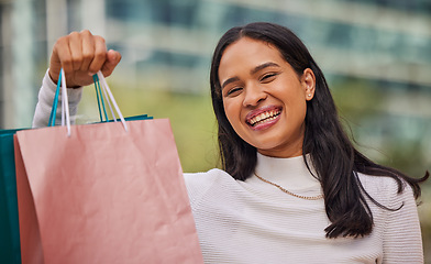 Image showing Face, smile and woman with shopping bags in city after shopping at retail shop, store or mall for clothing sale. Portrait, fashion and young female from India happy with sales purchase from boutique.