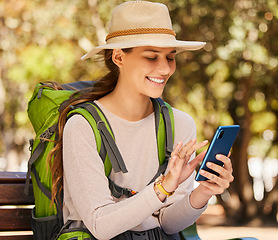 Image showing Hiking, phone and woman checking gps or online map in a forest, happy, relax and navigation. Nature, adventure and smiling woman exploring the woods, sitting to text and read message on smartphone