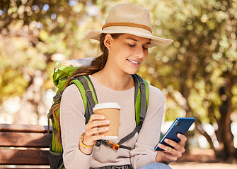 Image showing Phone, coffee and travel with a woman backpacker using 5g mobile technology for directions or navigation in a park. Social media, tourism and communication with a young woman typing a text message