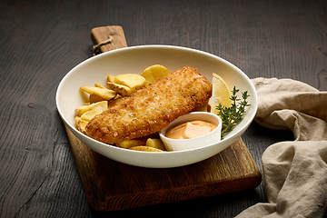 Image showing bowl of breaded fish fillet and fried potato wedges