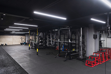 Image showing An empty modern gymnasium with a variety of equipment, offering a spacious, functional, and well-equipped training facility for workouts, fitness, and strength training