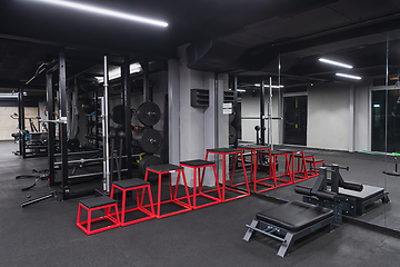 Image showing An empty modern gymnasium with a variety of equipment, offering a spacious, functional, and well-equipped training facility for workouts, fitness, and strength training