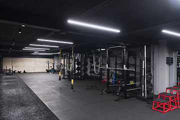 Image showing An empty modern gymnasium with a variety of equipment, offering a spacious, functional, and well-equipped training facility for workouts, fitness, and strength training