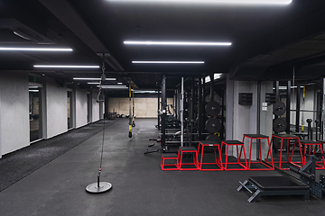 Image showing An empty modern gymnasium with a variety of equipment, offering a spacious, functional, and well-equipped training facility for workouts, fitness, and strength training