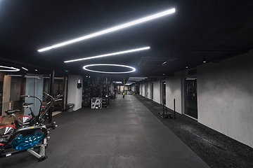 Image showing An empty modern gymnasium with a variety of equipment, offering a spacious, functional, and well-equipped training facility for workouts, fitness, and strength training