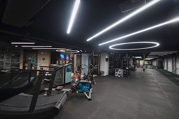 Image showing An empty modern gymnasium with a variety of equipment, offering a spacious, functional, and well-equipped training facility for workouts, fitness, and strength training