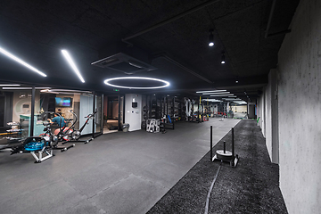 Image showing An empty modern gymnasium with a variety of equipment, offering a spacious, functional, and well-equipped training facility for workouts, fitness, and strength training