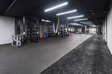 Image showing An empty modern gymnasium with a variety of equipment, offering a spacious, functional, and well-equipped training facility for workouts, fitness, and strength training