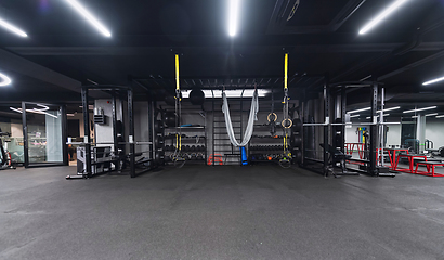 Image showing An empty modern gymnasium with a variety of equipment, offering a spacious, functional, and well-equipped training facility for workouts, fitness, and strength training