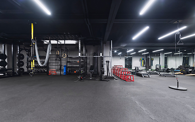 Image showing An empty modern gymnasium with a variety of equipment, offering a spacious, functional, and well-equipped training facility for workouts, fitness, and strength training