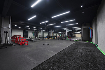 Image showing An empty modern gymnasium with a variety of equipment, offering a spacious, functional, and well-equipped training facility for workouts, fitness, and strength training