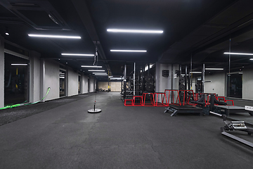 Image showing An empty modern gymnasium with a variety of equipment, offering a spacious, functional, and well-equipped training facility for workouts, fitness, and strength training