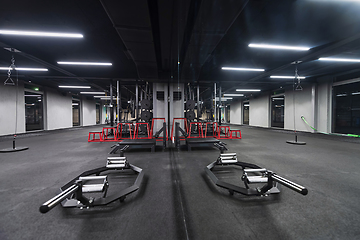 Image showing An empty modern gymnasium with a variety of equipment, offering a spacious, functional, and well-equipped training facility for workouts, fitness, and strength training