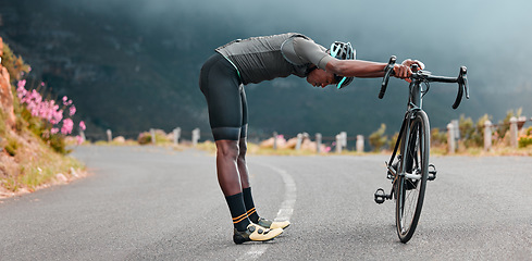 Image showing Sports man, stretch and cycling break along mountain route by cyclist resting during fitness, exercise and morning cardio. Stretching, bicycle and black man stop for rest during physical performance