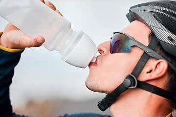 Image showing Fitness, cycling and man drinking water in bottle during a cycle marathon, training or exercise. Cardio, sports and thirsty biker athlete enjoying a refreshing drink, liquid or beverage while biking.