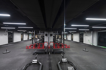 Image showing An empty modern gymnasium with a variety of equipment, offering a spacious, functional, and well-equipped training facility for workouts, fitness, and strength training